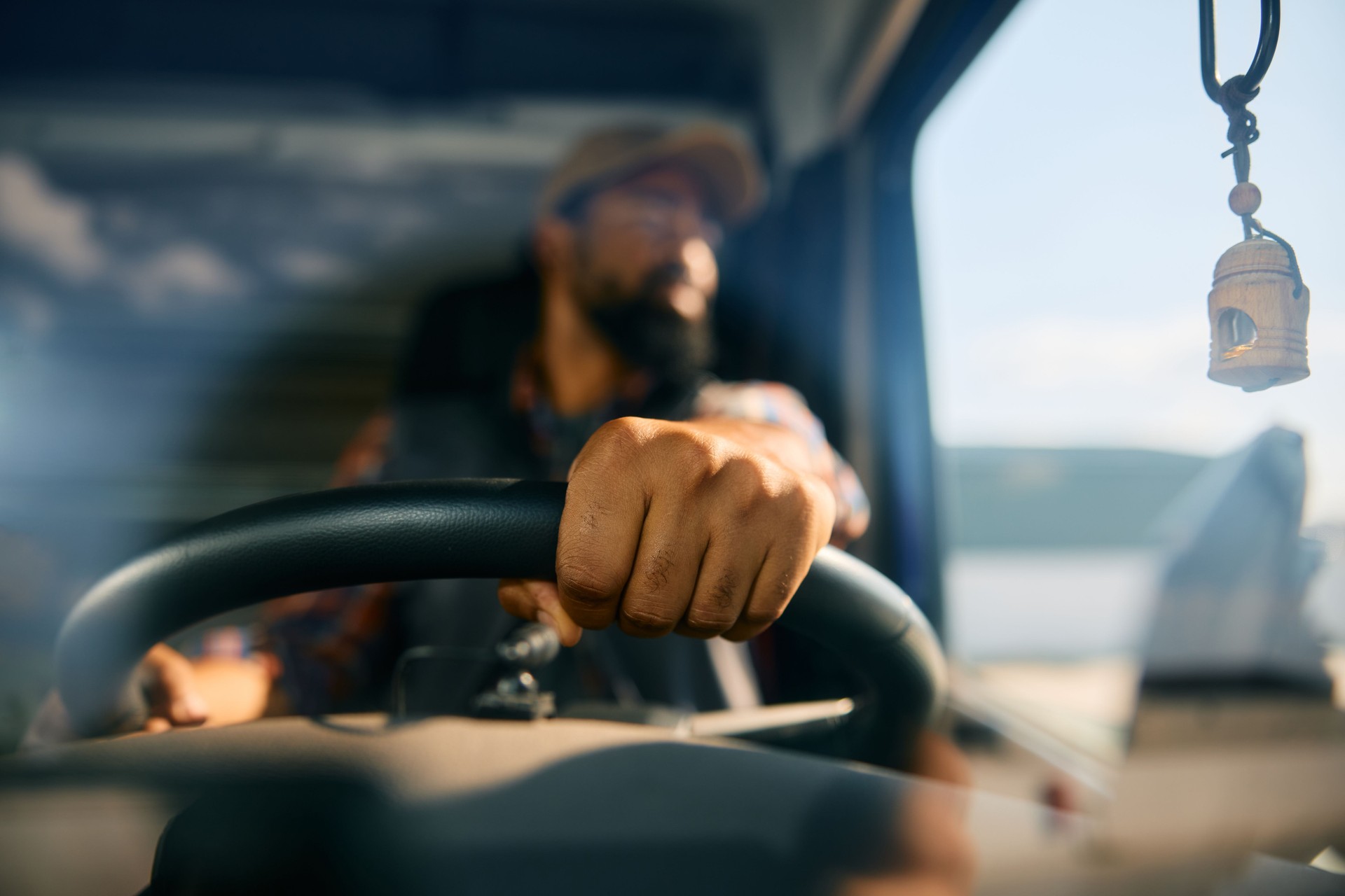 Close up of black truck driver behind the steering wheel.